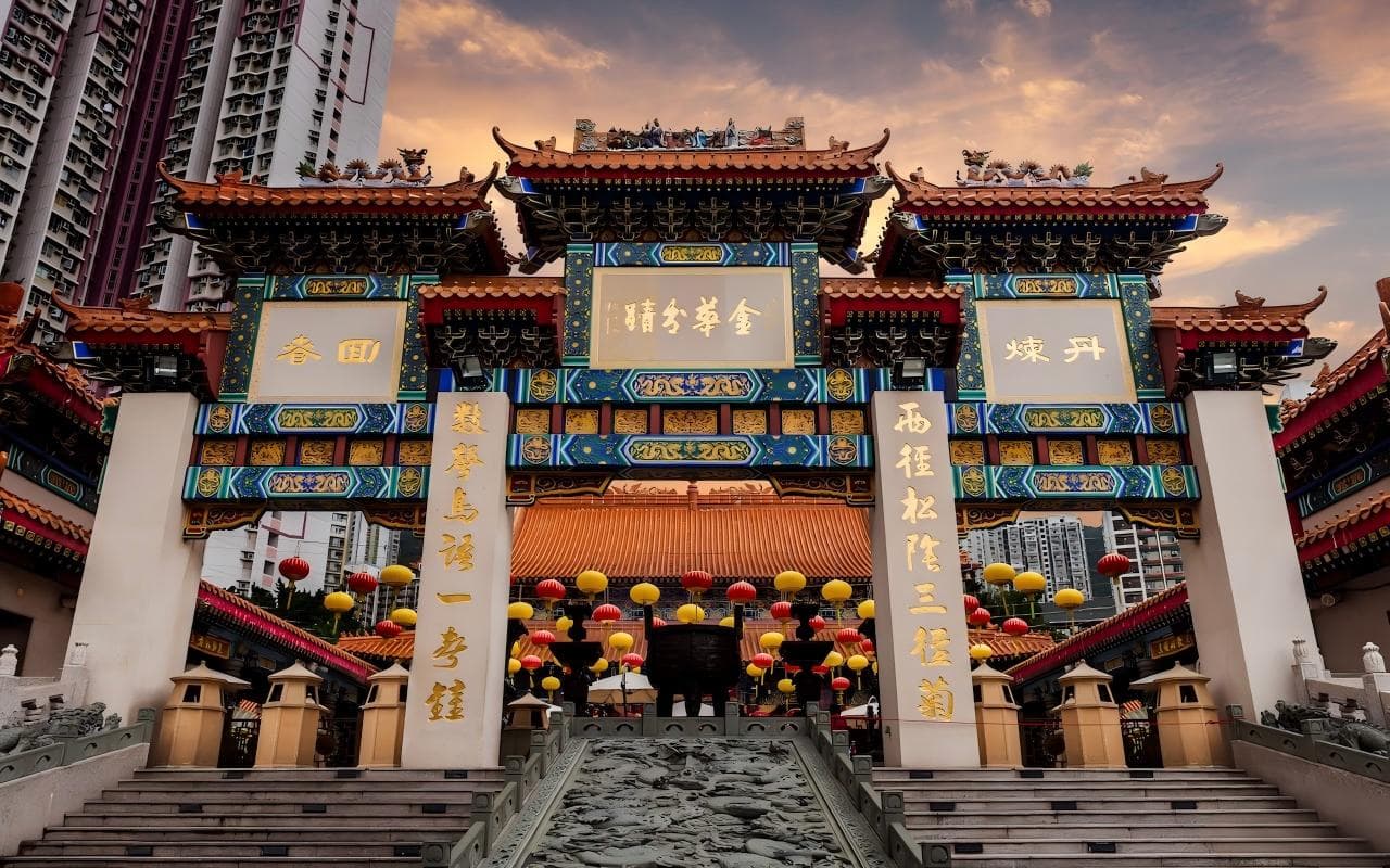 香港嗇色園黃大仙祠牌坊,牌坊上可見金華分蹟與嗇色園題字,背景為住宅樓宇